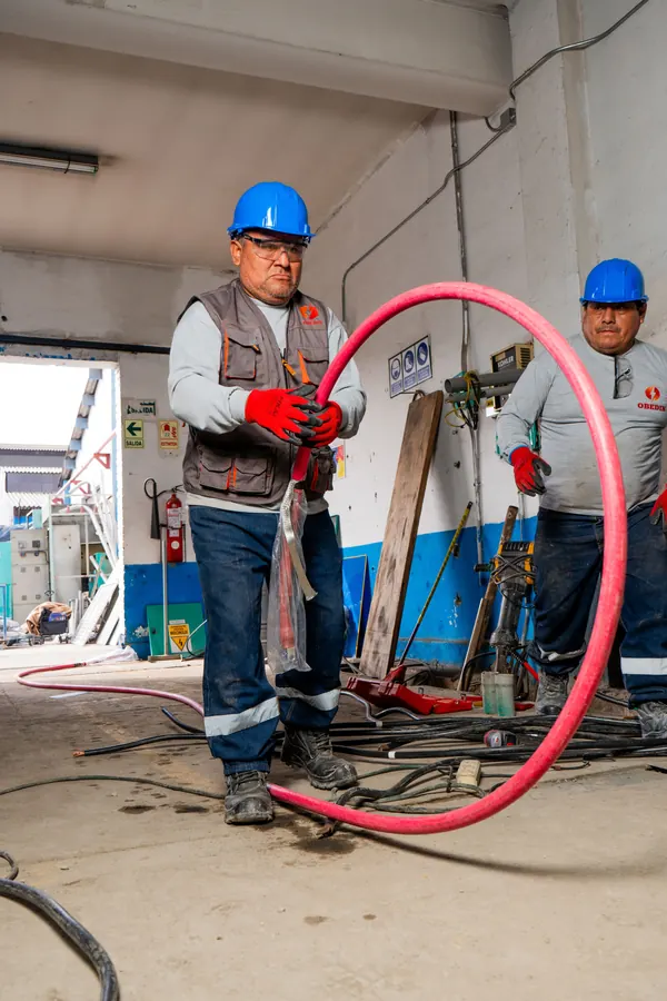 Dos técnicos de OBEDIN preparan un cable eléctrico en obra
