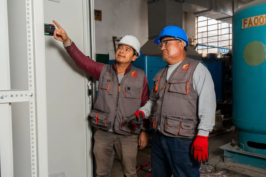 Dos técnicos de OBEDIN revisan un tablero eléctrico