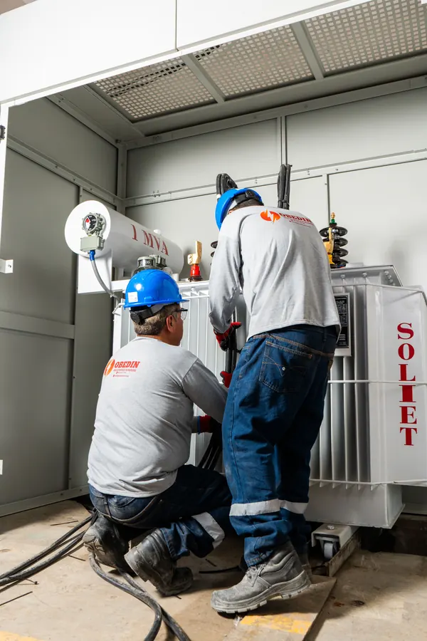 Técnicos de OBEDIN conectan cables junto al transformador de REYEMSA